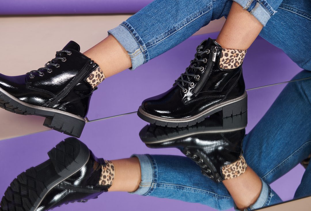 A close-up of black boots styled with jeans