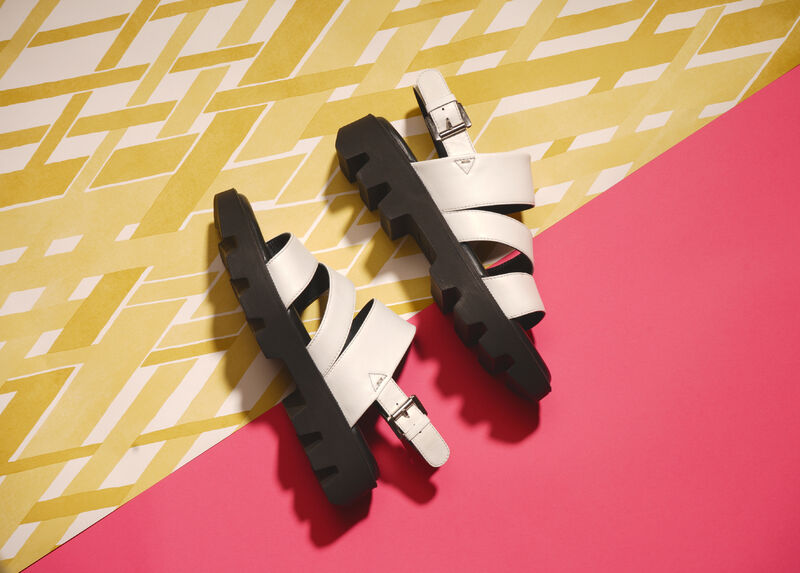 Xena sandals against a pink and gold background - product shot